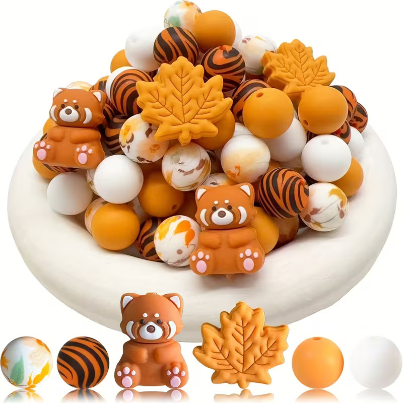 Autumn silicone bead set with red panda and maple leaf focal beads, tiger stripe patterns, and assorted orange and white round beads for jewelry making